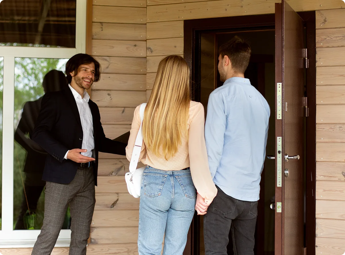 An agent handing over keys to a couple at a property