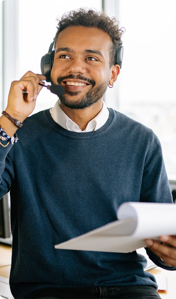 A sales representative wearing a headset and holding a notepad