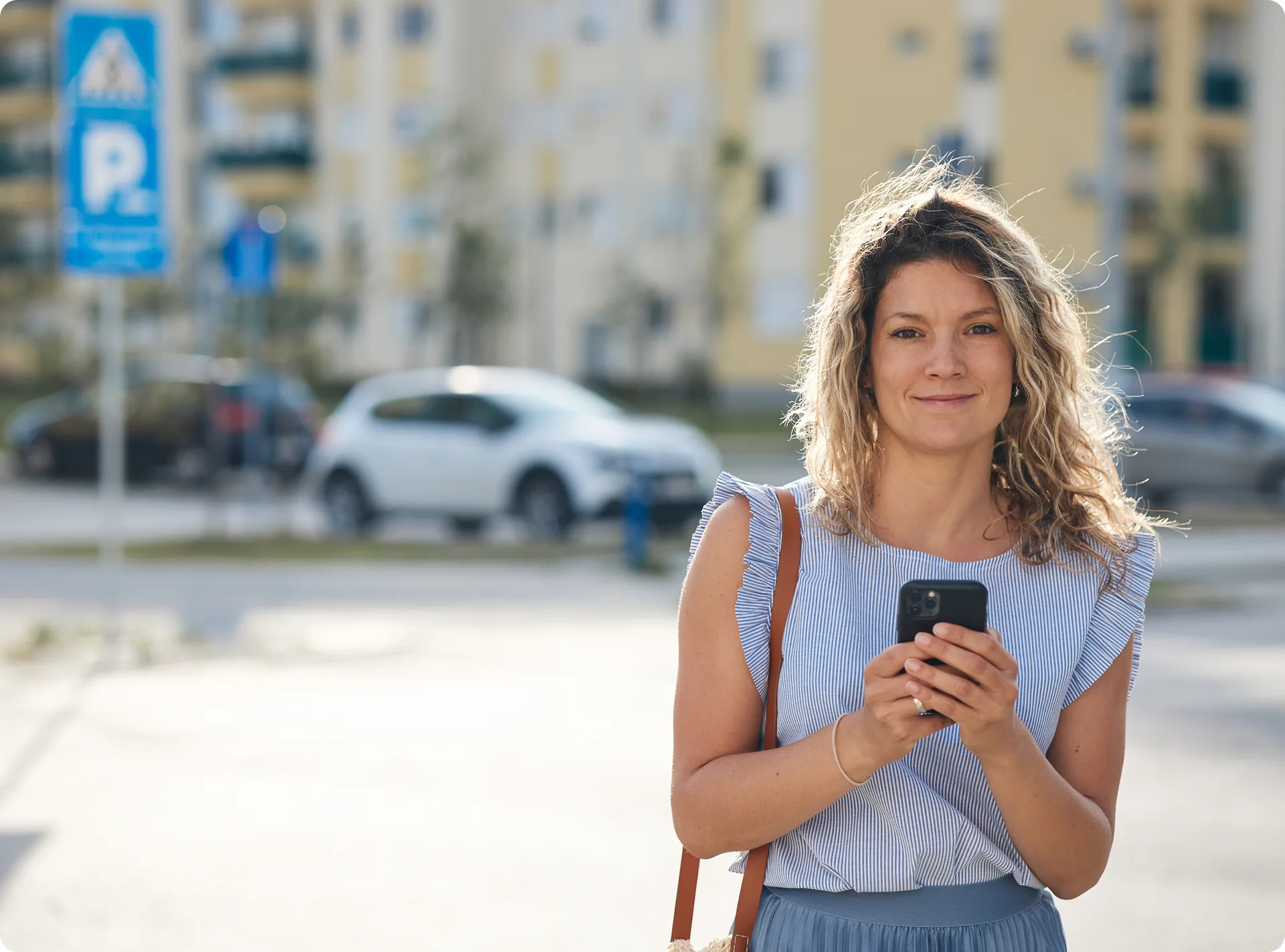 A resident checking their phone outside an apartment block
