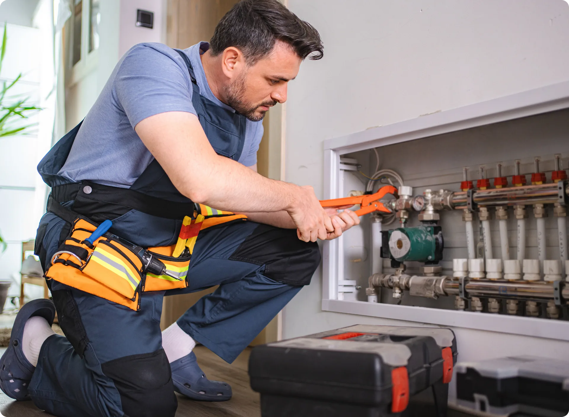 A plumber repairing a heating manifold