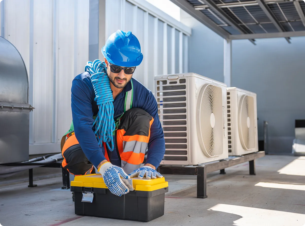 A technician servicing rooftop air conditioning units