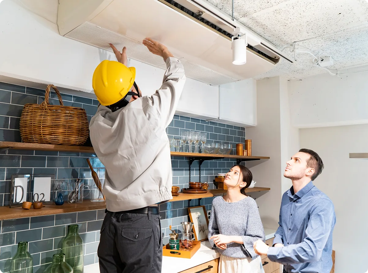 A technician servicing a unit while clients look on