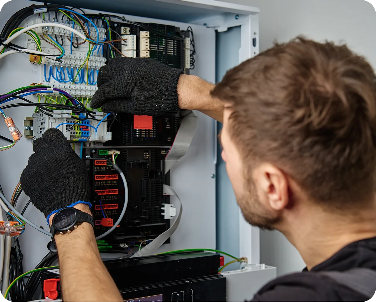 An electrician working on a distribution panel