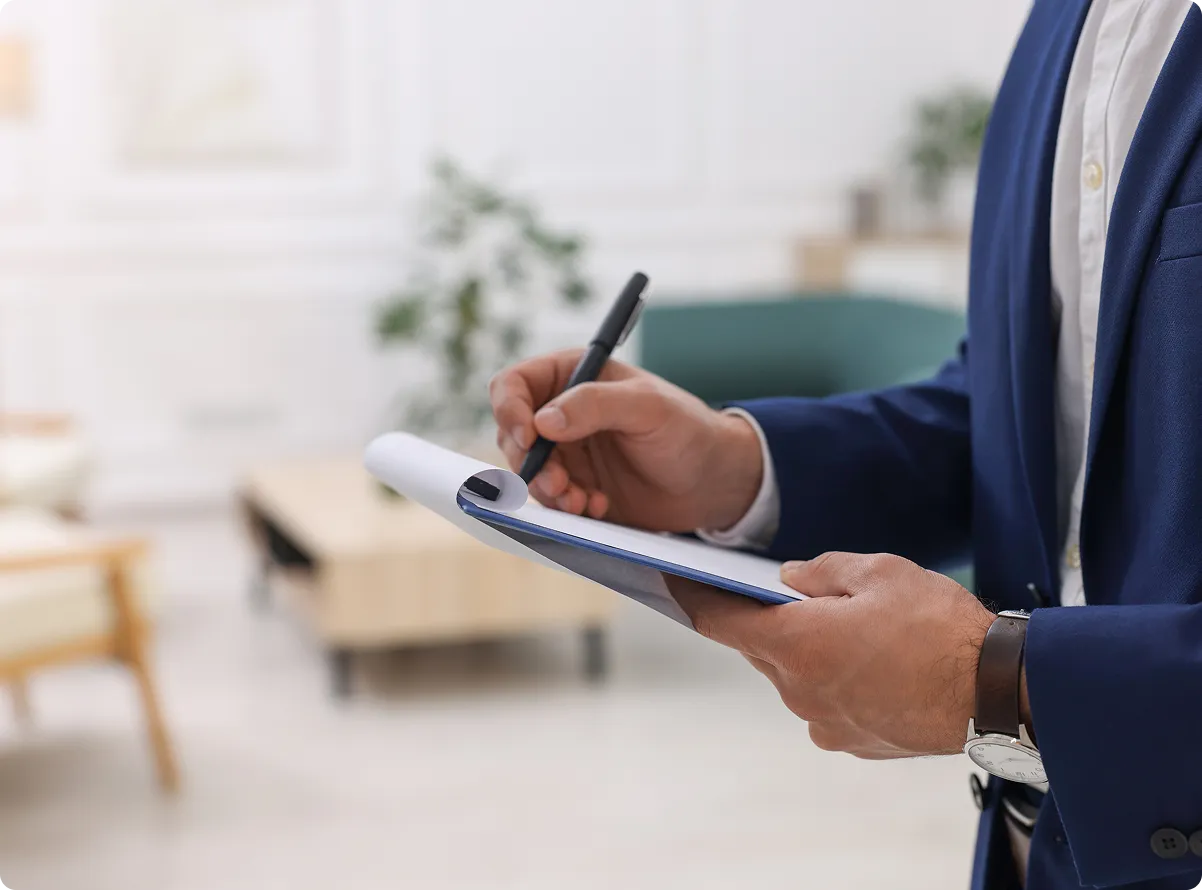 A property manager taking notes on a clipboard in a lobby