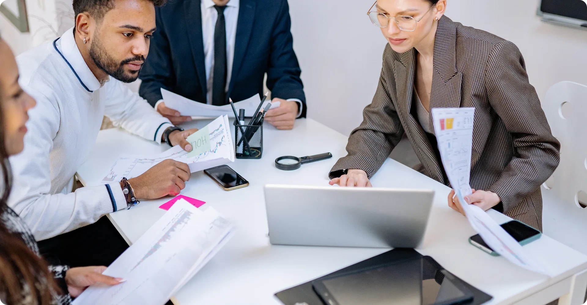 A property management team reviewing reports around a desk