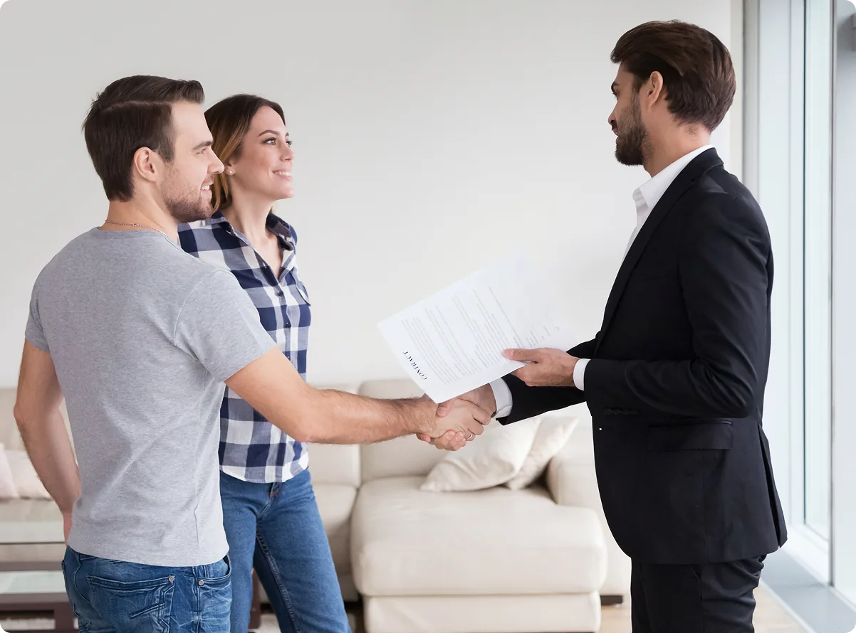 A property manager shaking hands with two new tenants