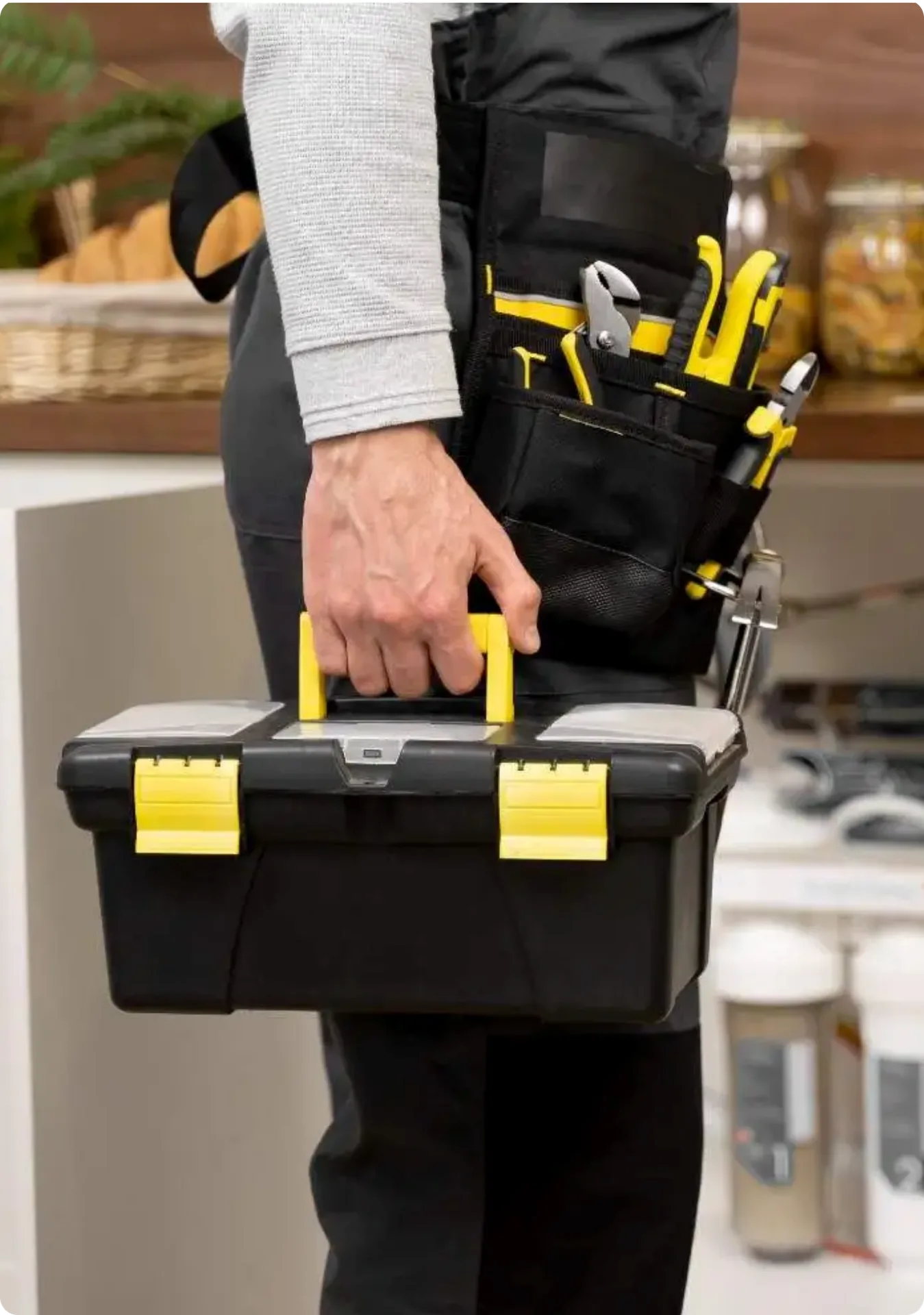 A maintenance technician carrying a toolbox into a property