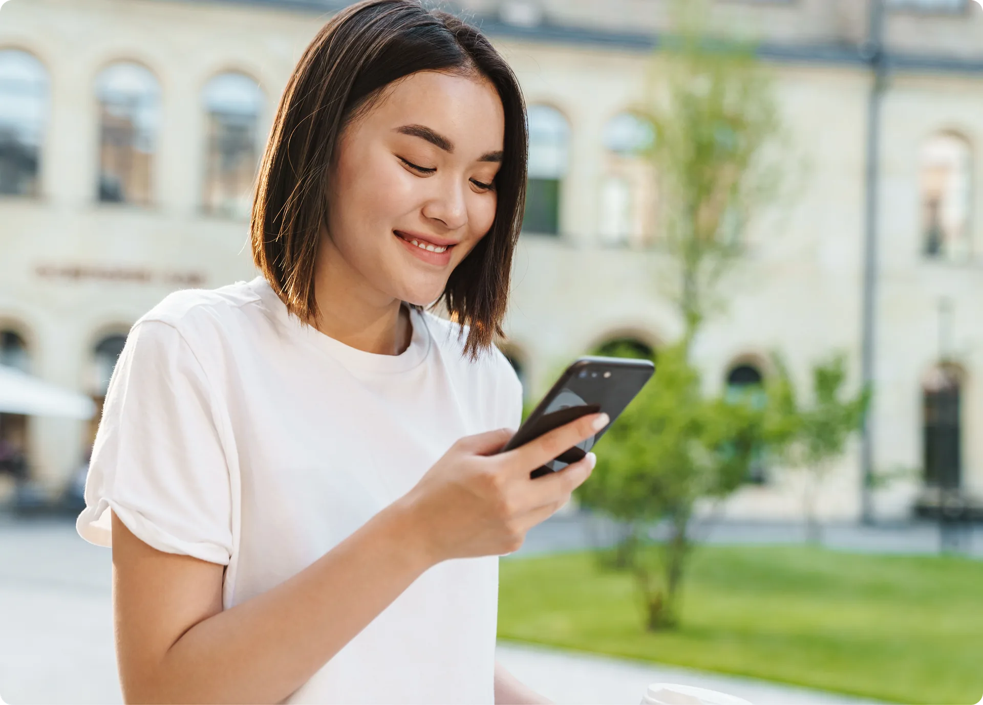 A person checking their phone outside an apartment building